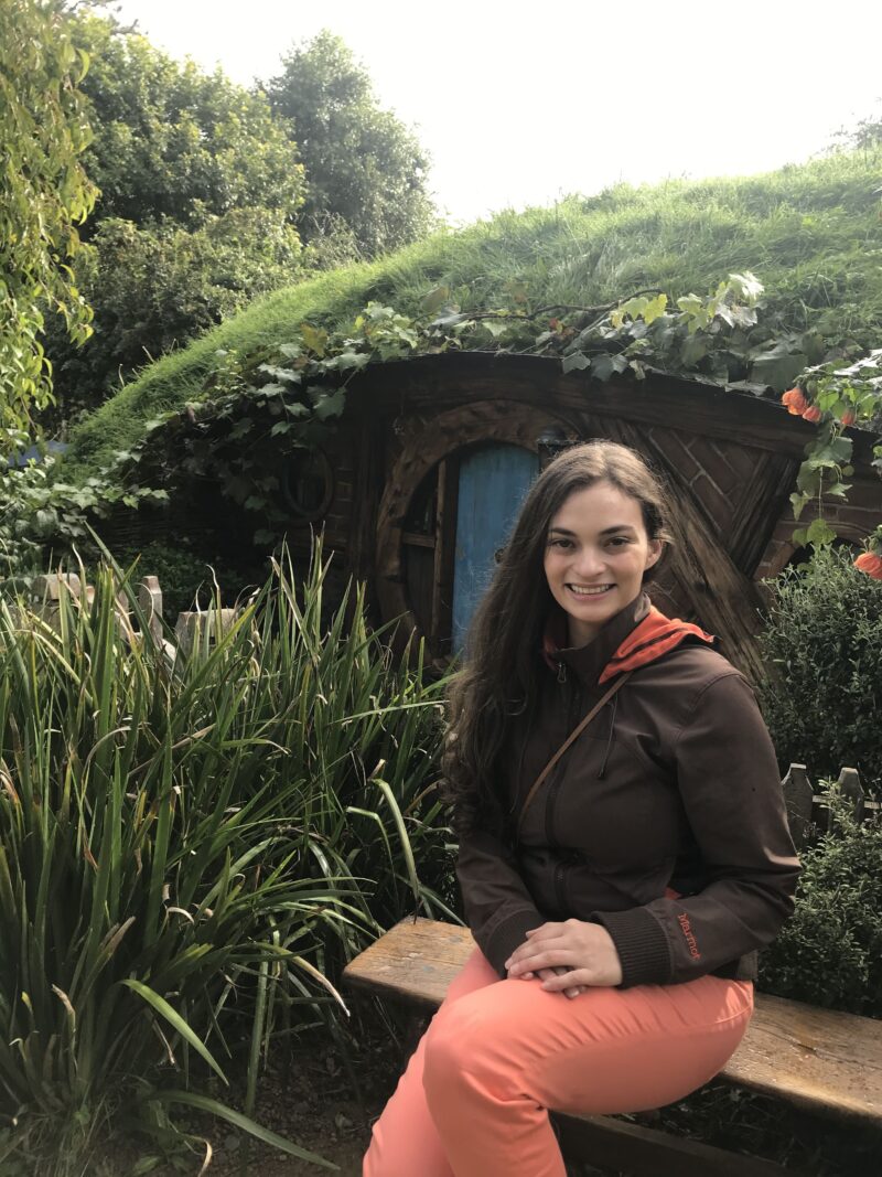 Woman sitting in front of hobbit house