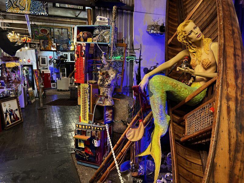 Collection of artwork in passageway, including visible mermaid