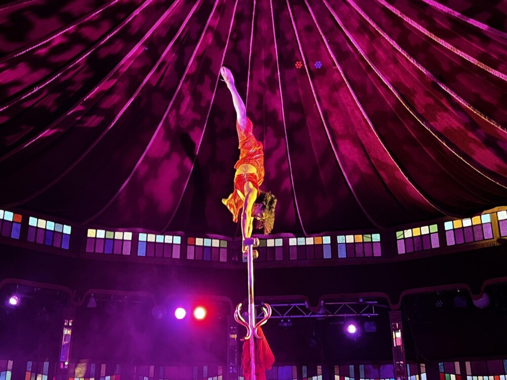 Performer balancing upside down on beam