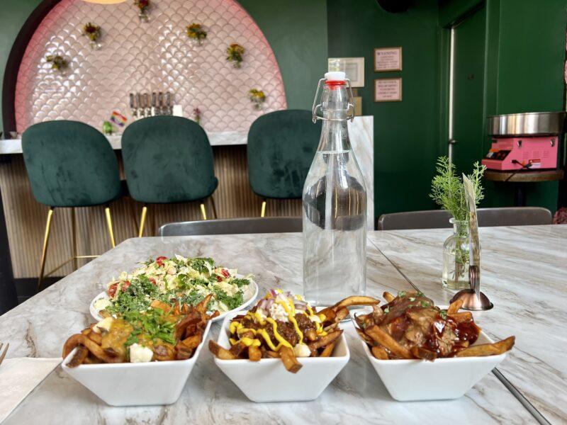 Poutine flight of 3 options lined up on table