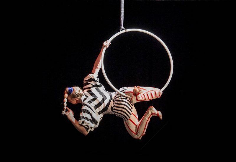 Acrobat hanging from a hoop