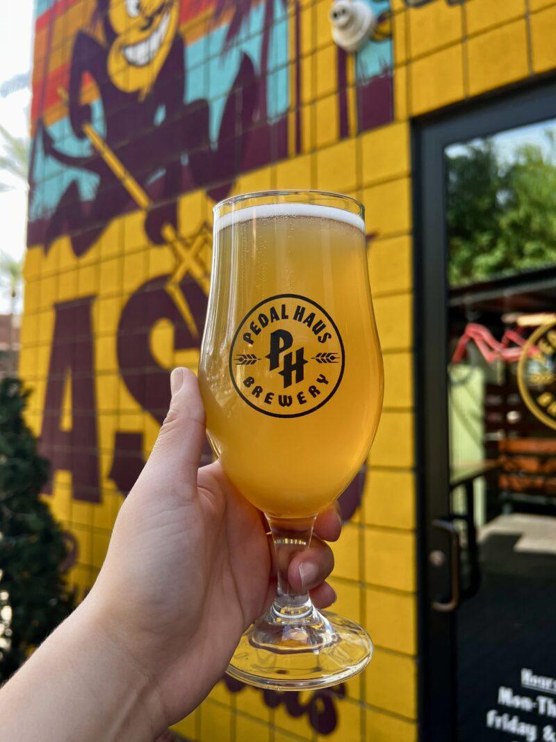 Holding beer in front of mural