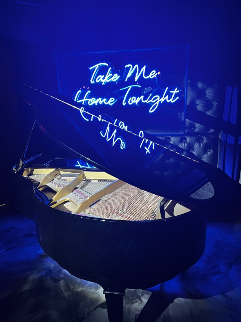 Piano with electric sign above it