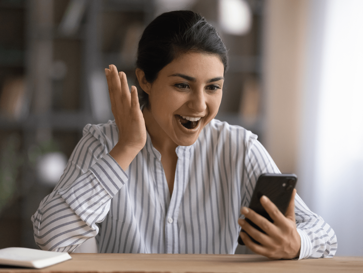 Woman excitedly looking at phone