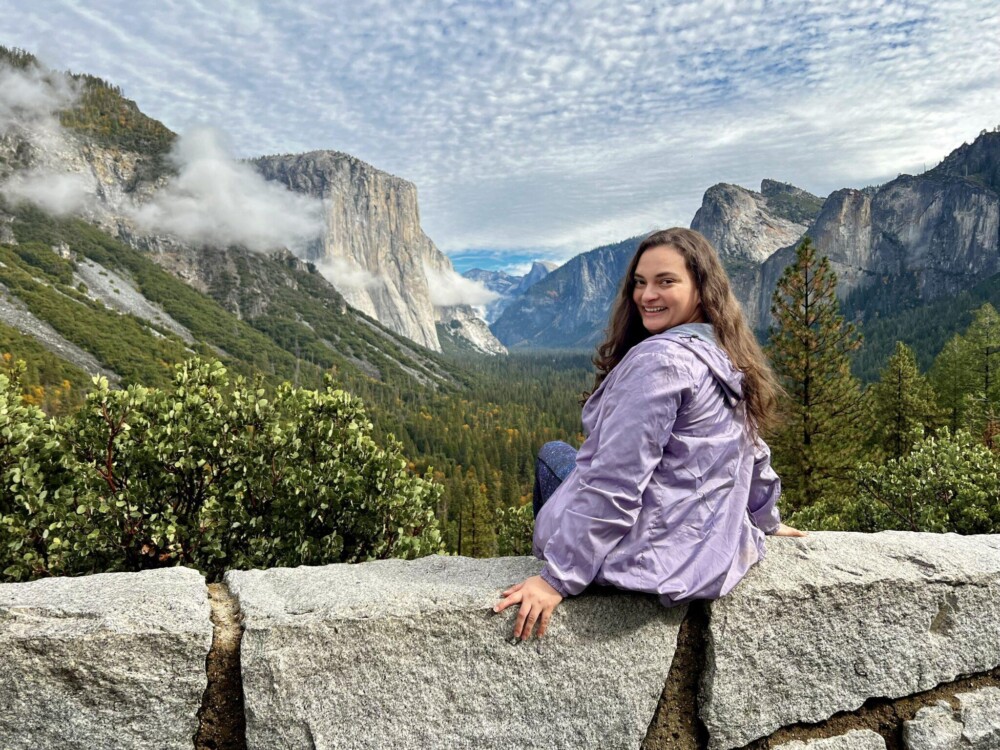 Woman looking back over shoulder with nature view in front of her