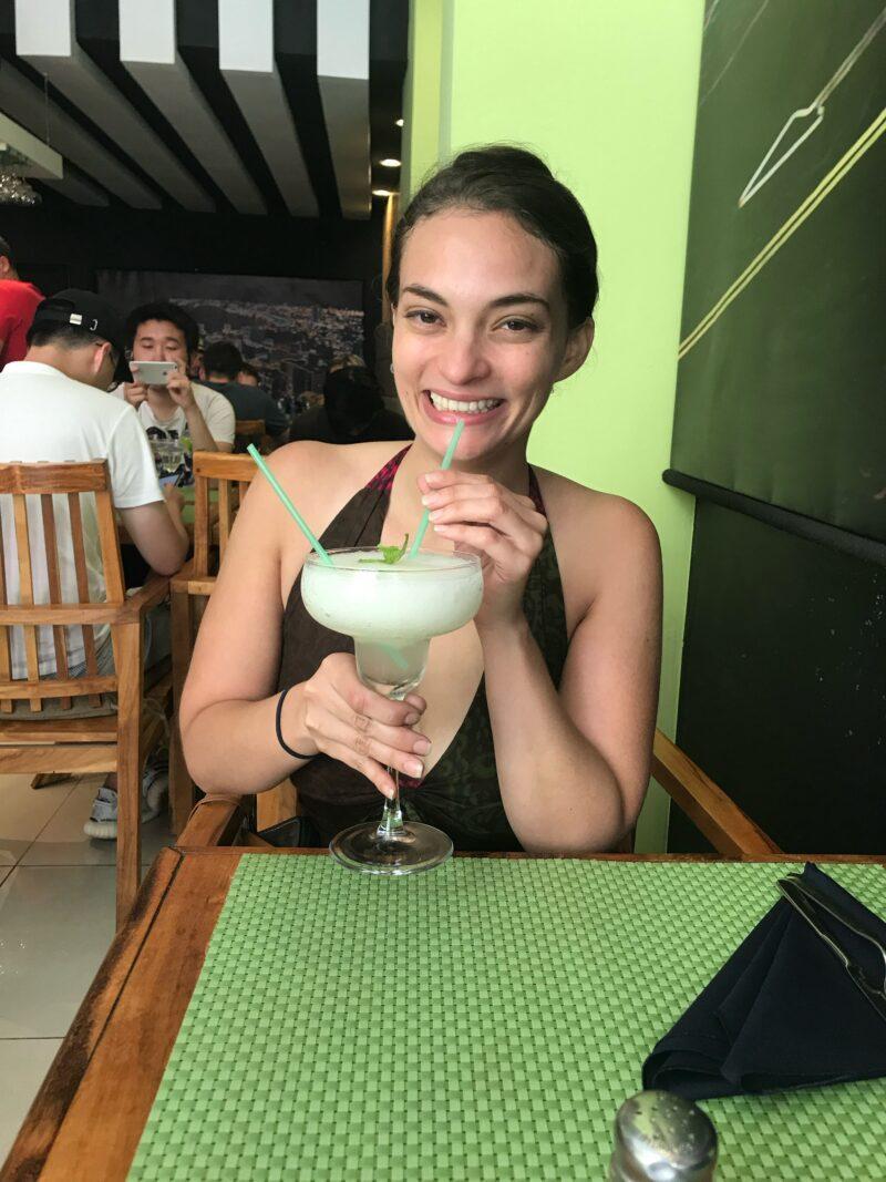 Girl sipping frozen mojito