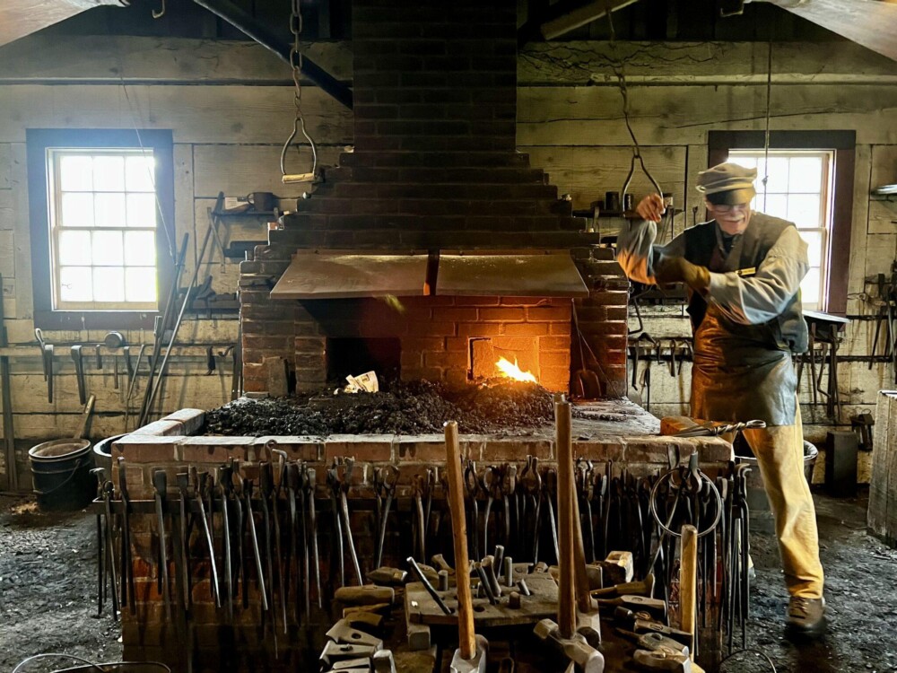 Blacksmith working to get fire going