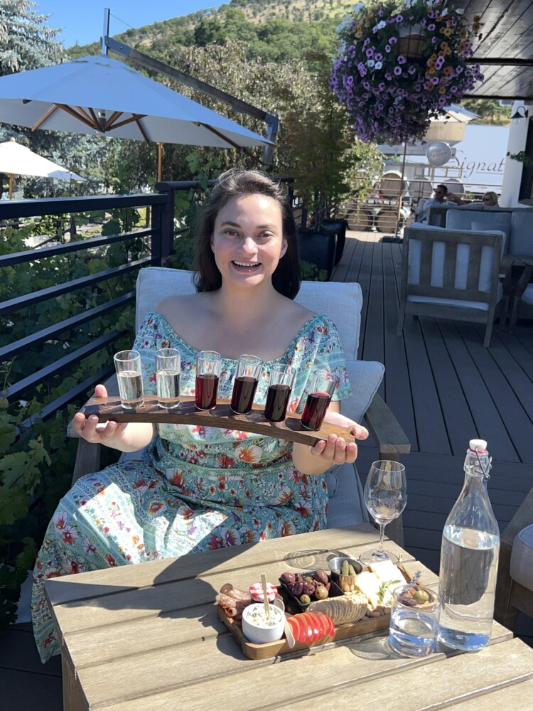 Woman holding wine flight while seated at winery