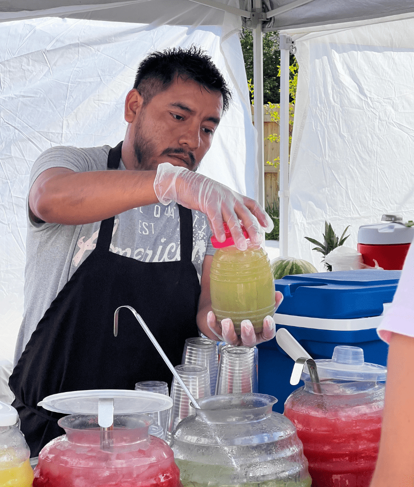 Man selling drinks at El Mercadito