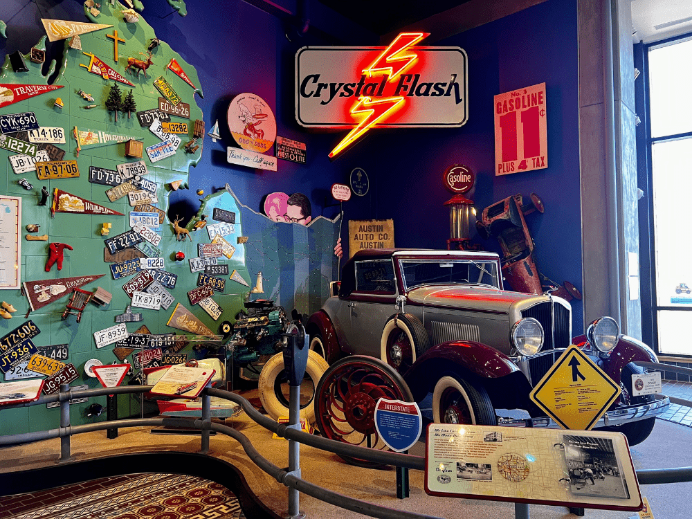 Museum display with car and neon lightning bolt above